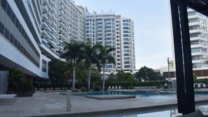 A pool area with a view of high-rise buildings in the background. - Santa Marta: Sunset View, Pools, and Private Beach in Pozos Colorados (Santa Marta)