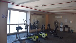 A gym with various exercise equipment, including a stationary bike, elliptical, and dumbbells. - Santa Marta: Sunset View, Pools, and Private Beach in Pozos Colorados (Santa Marta)