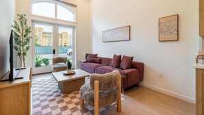 A modern living room with a sofa, armchair, and coffee table. - Premium 1B1B Living with Pool, Spa and Smart 4K TVs (Montclair)