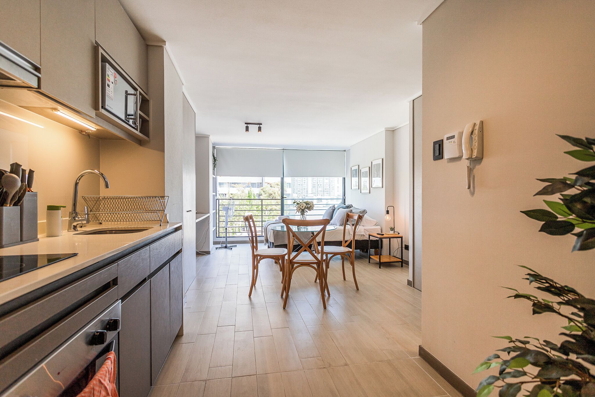 Eine moderne Küche mit Essbereich, einem eingebauten Backofen und einem großen Fenster mit Blick auf die Stadt.