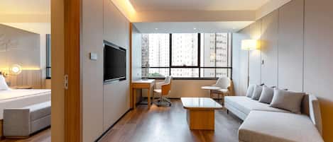 A modern living room with a sofa, a coffee table, and a TV.