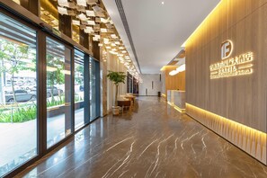 Un moderno vestíbulo de hotel con suelo de mármol, amplias ventanas y una recepción.