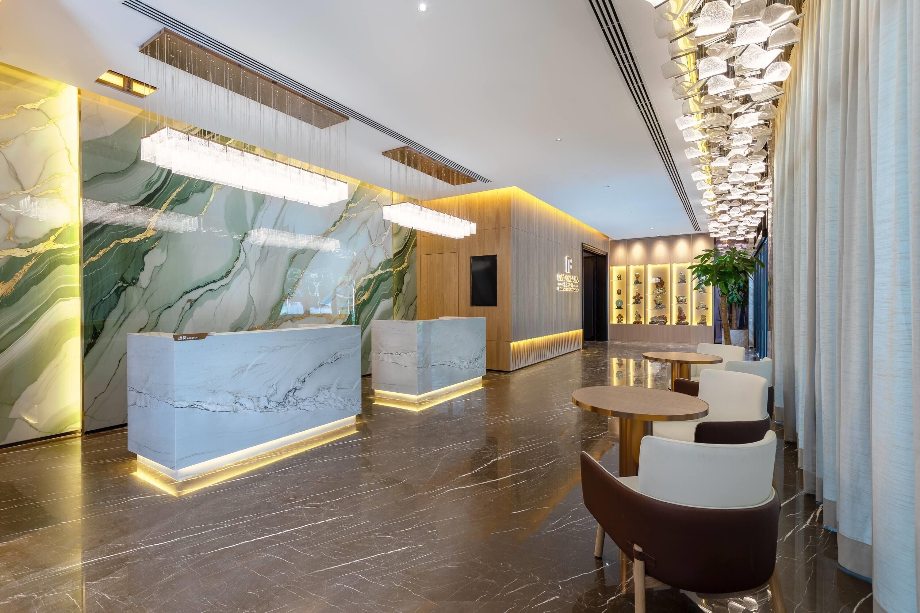Un moderno vestíbulo de hotel con mostradores de recepción de mármol, una zona de recepción y arreglos de asientos.