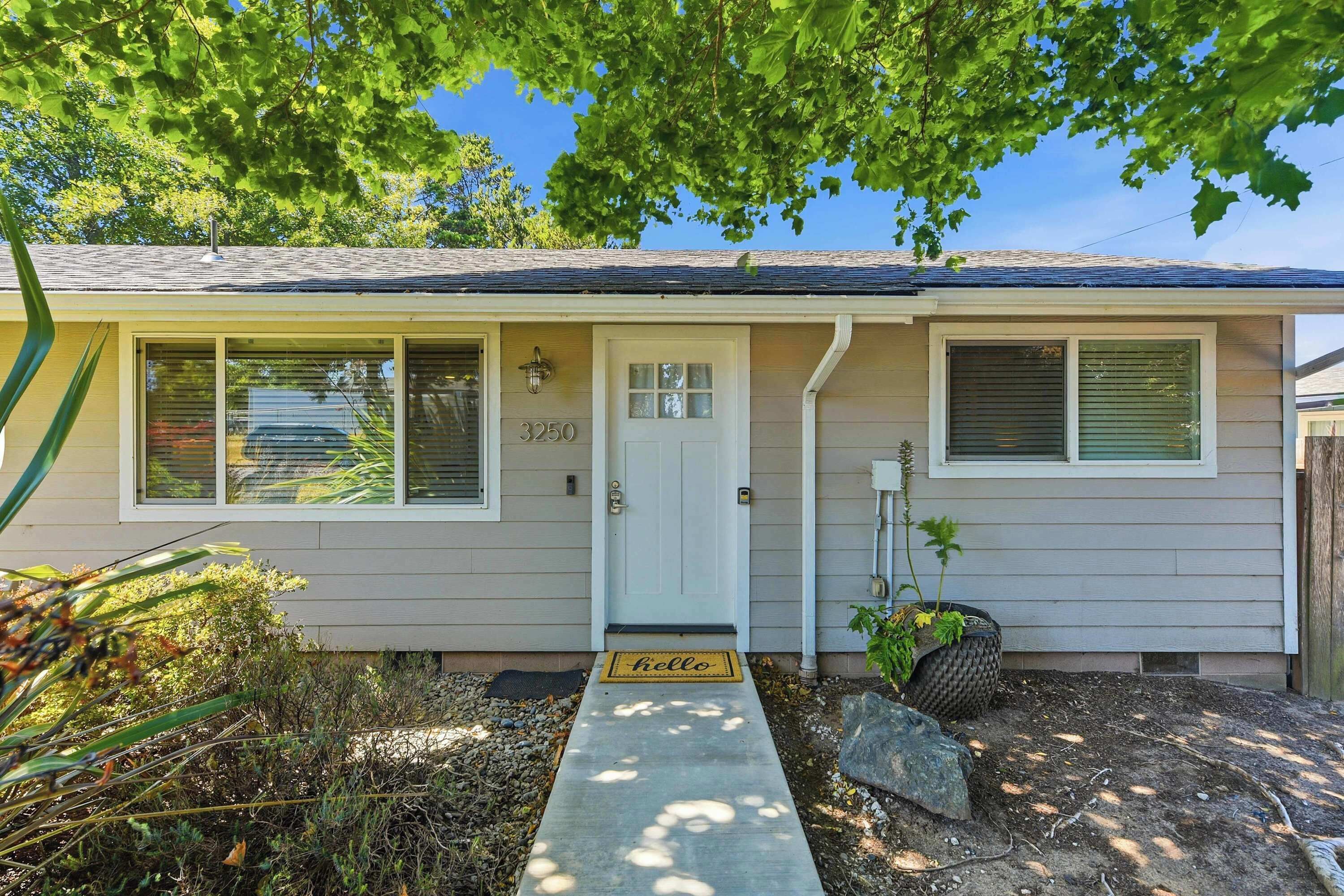 A single-story house with a front door, two windows with shutters, and a mailbox.