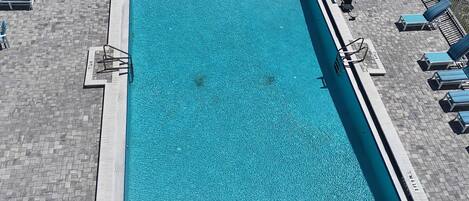 Una piscina rectangular con un borde de baldosas alrededor.