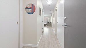 A hallway with a door on the left, a circular sign with text, and a door on the right.