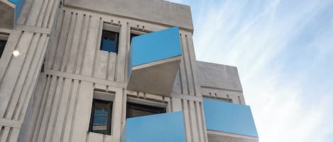 Un edificio de varios pisos con un estilo arquitectónico moderno, que cuenta con una serie de balcones y ventanas.