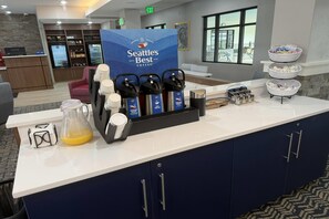 A coffee station with Seattle's Best branded coffee makers and a variety of coffee pods. - AmericInn By Wyndham Mountain Lake Mn (Mountain Lake)
