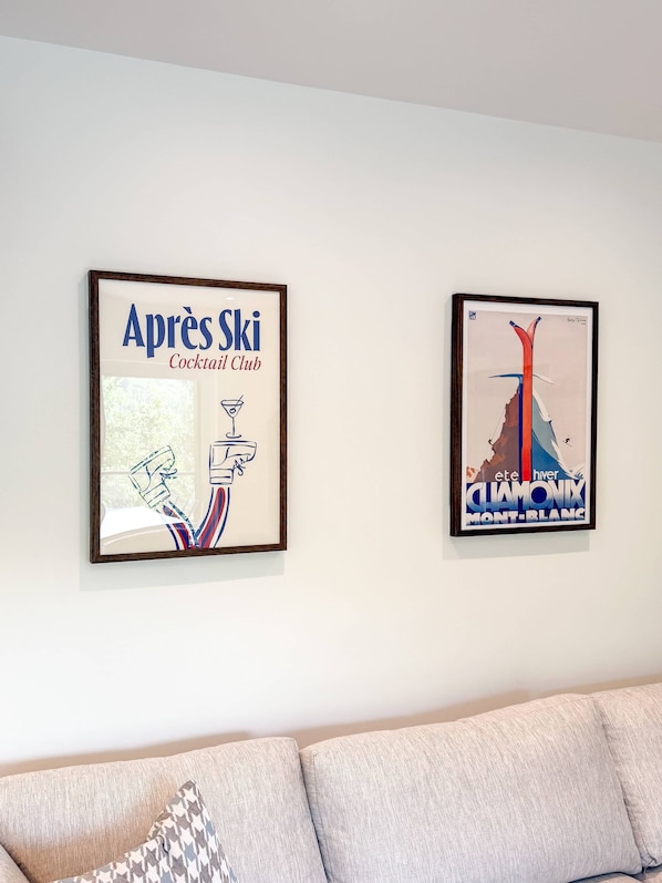 Zwei gerahmte Kunstwerke hängen über einer Couch an der Wand.