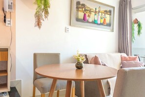 Ein modernes Wohnzimmer mit einem runden Holztisch, einer Couch und einem Bild an der Wand.