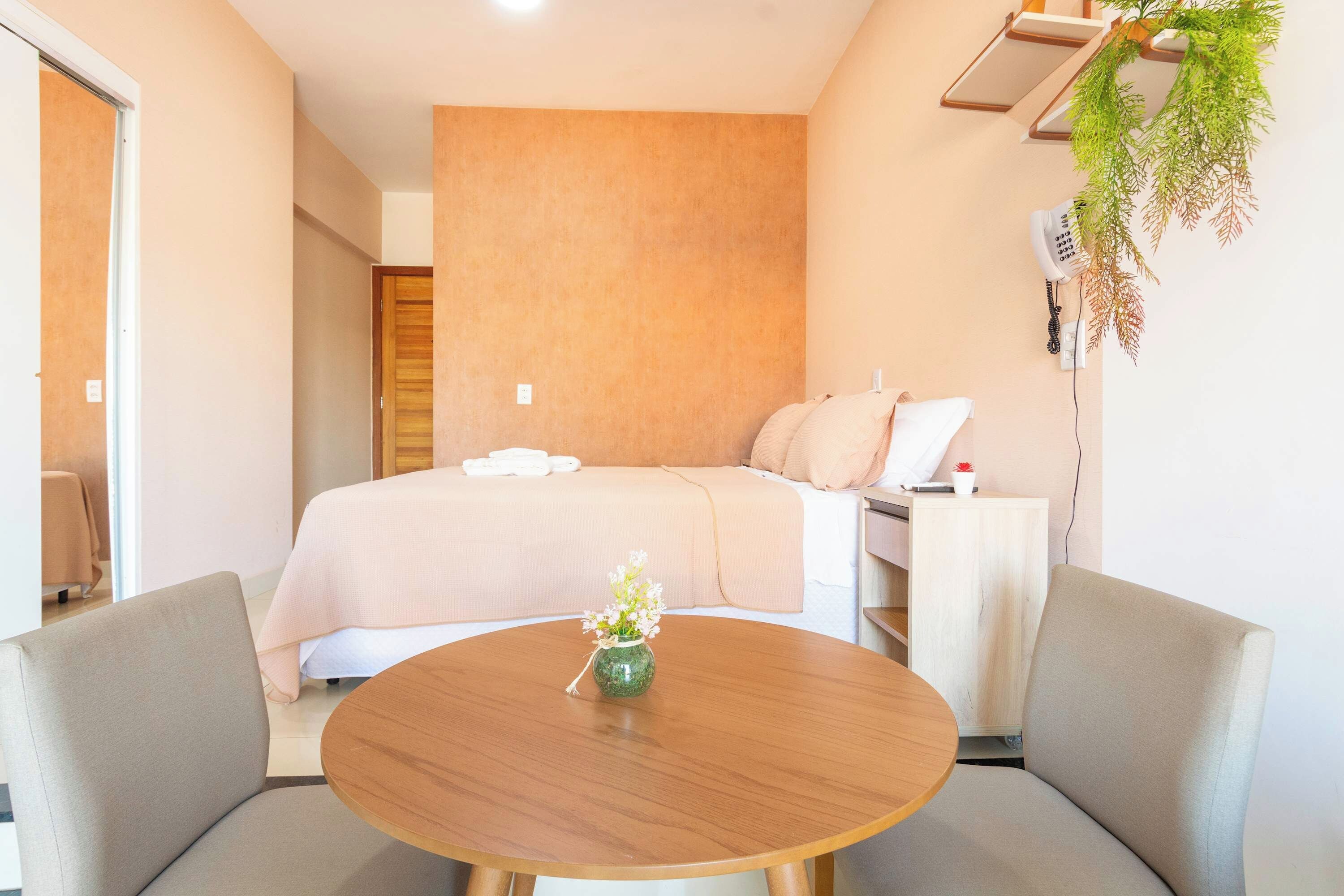 Une chambre d’hôtel avec un lit, une table de chevet et une table ronde avec des chaises.
