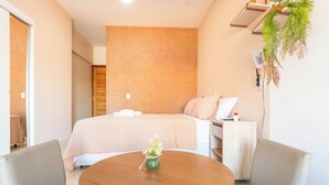 Una camera d'albergo con un letto, un comodino e un tavolo rotondo con sedie.