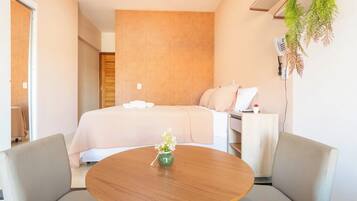 Une chambre d’hôtel avec un lit, une table de chevet et une table ronde avec des chaises.