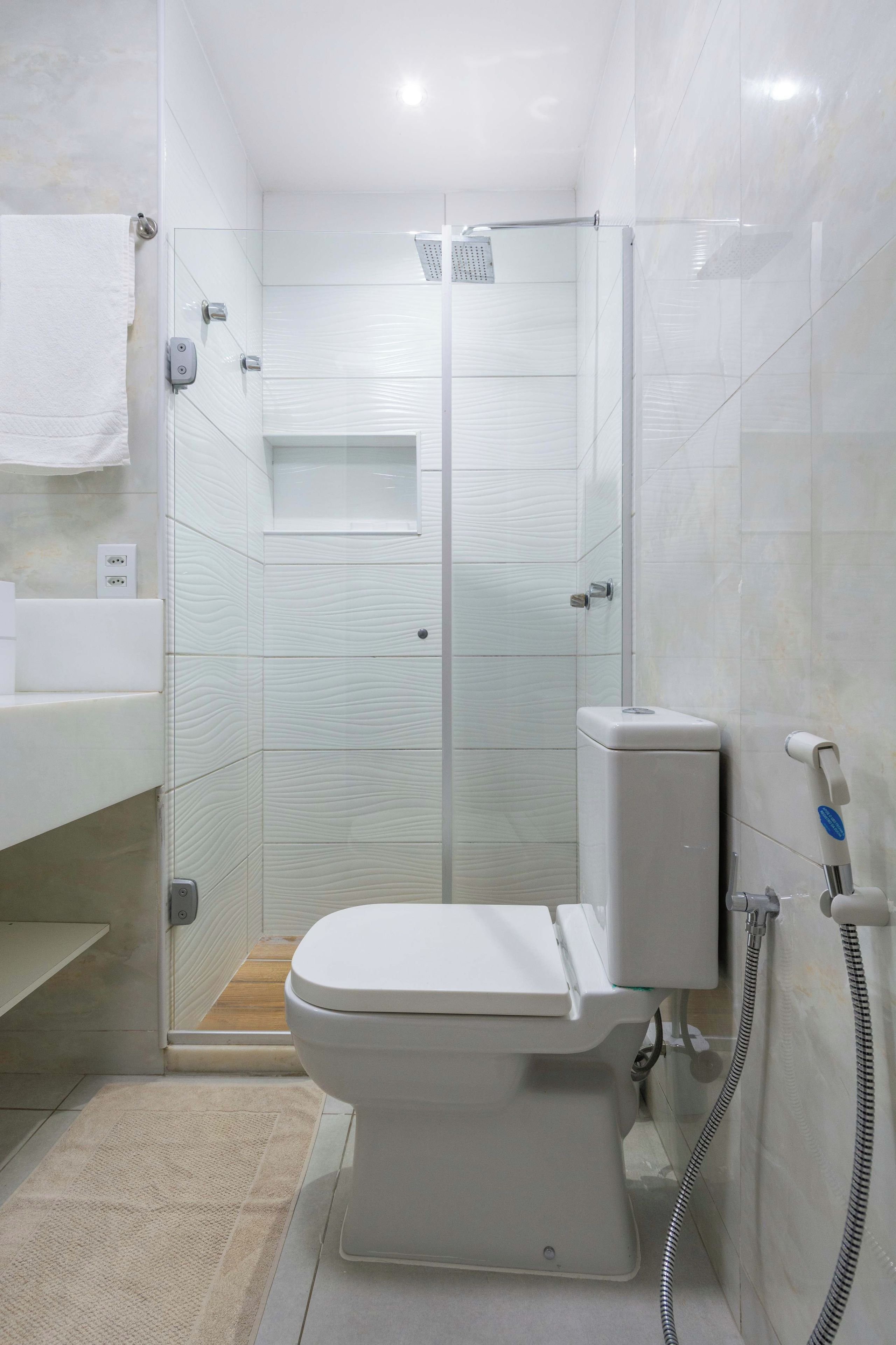 A modern bathroom with a toilet, a shower enclosure, and a sink.