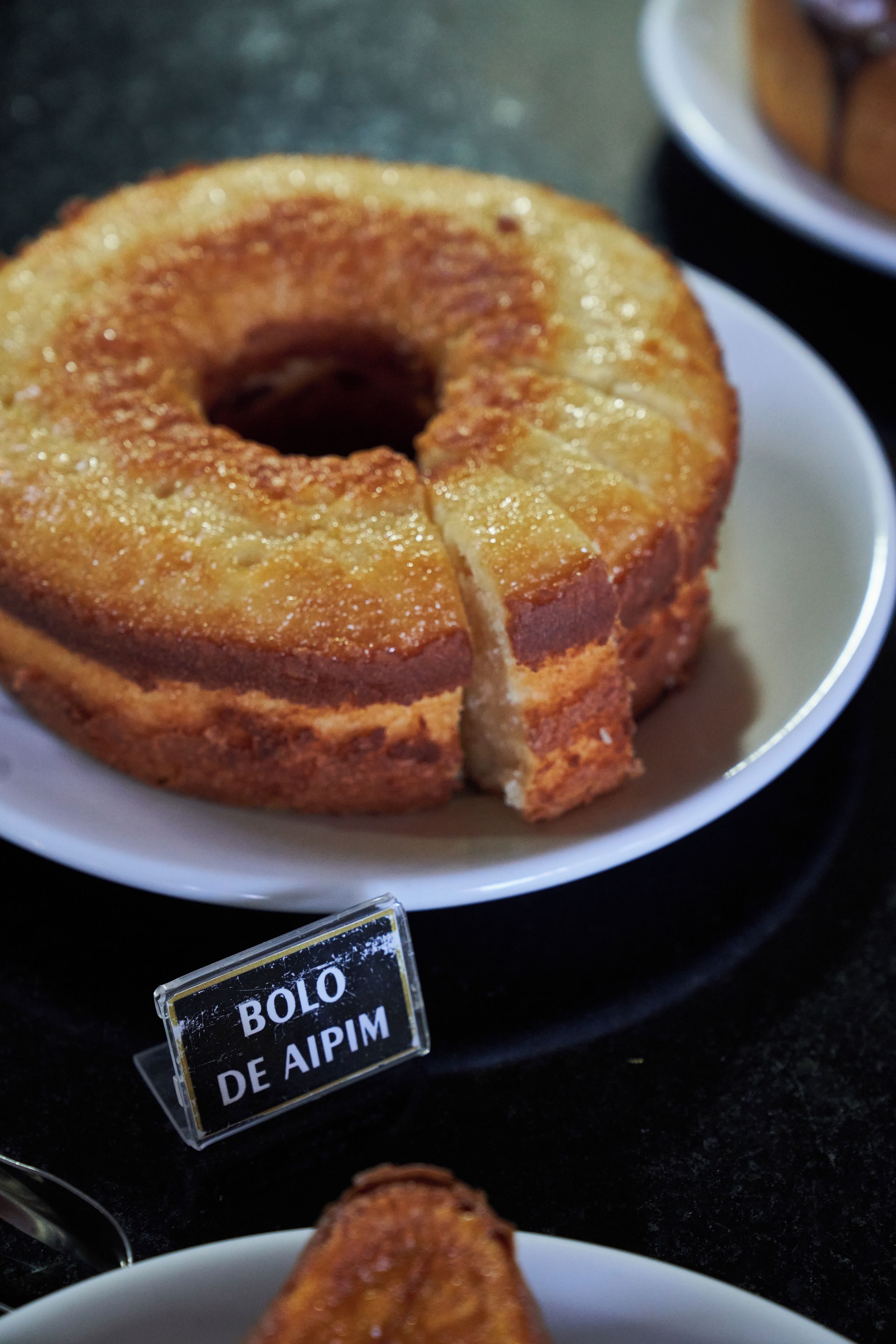 Un pastel con una etiqueta que dice 'Bolo de Aipim'.