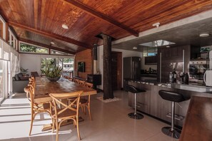 A spacious kitchen with modern appliances, a dining area with wooden furniture, and a large window providing natural light.
