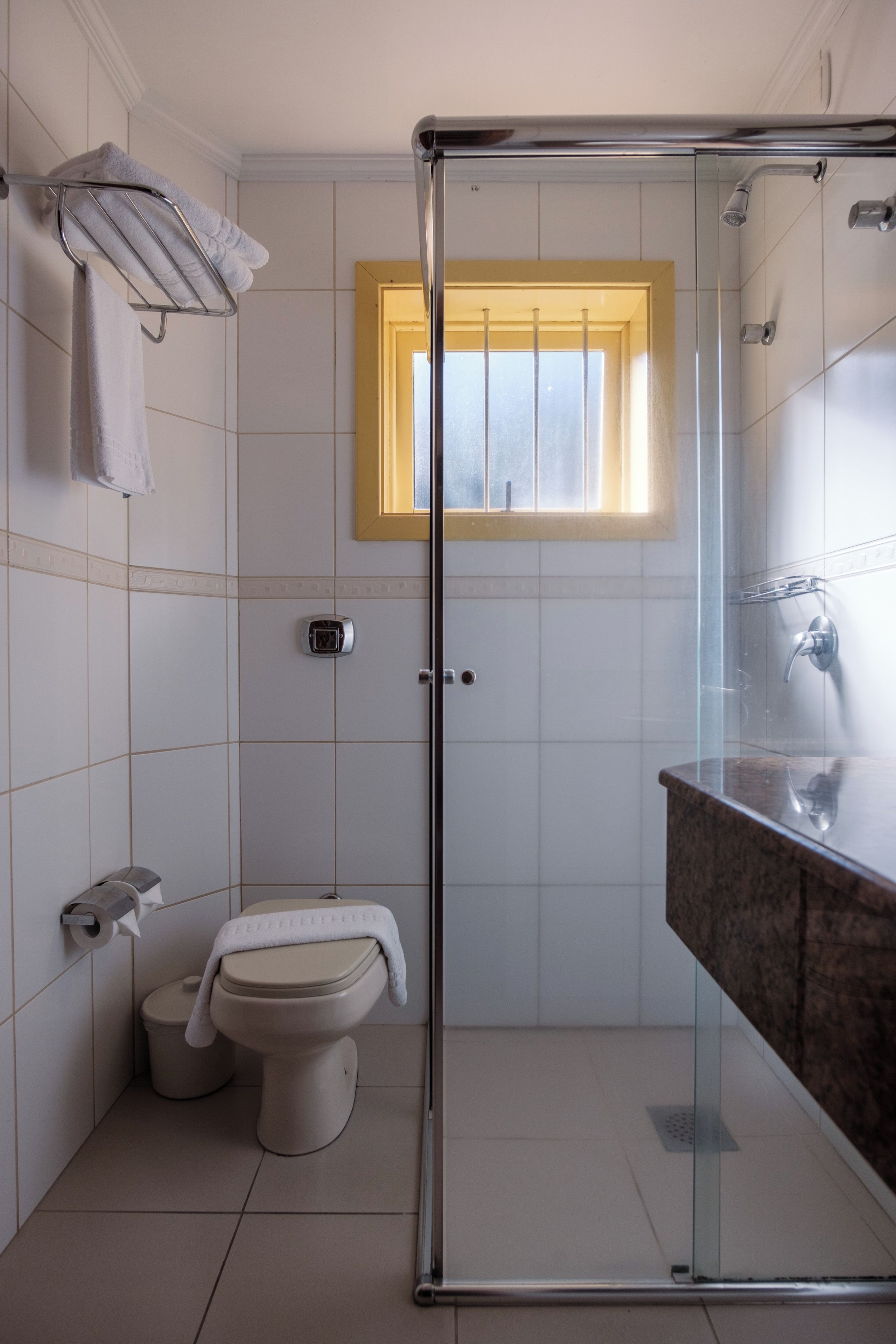 A modern bathroom with a glass-enclosed shower, a toilet, a bidet, and a vanity with a mirror.