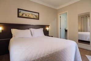 A hotel room with a large bed, a nightstand, a painting on the wall, and a mirror reflecting the bed. - Pousada do Chalé (Bento Gonçalves)
