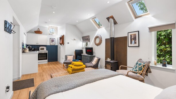 Een modern interieur met een keuken, een eethoek en een slaapkamer met een groot bed en een open haard.