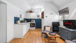 Een knus woongedeelte met kitchenette, een eethoek, een zithoek met televisie en een raam met uitzicht.