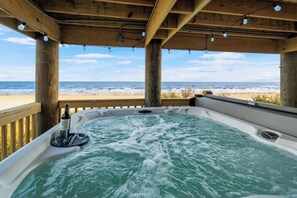 Uma banheira de hidromassagem com vista para a praia e o oceano.