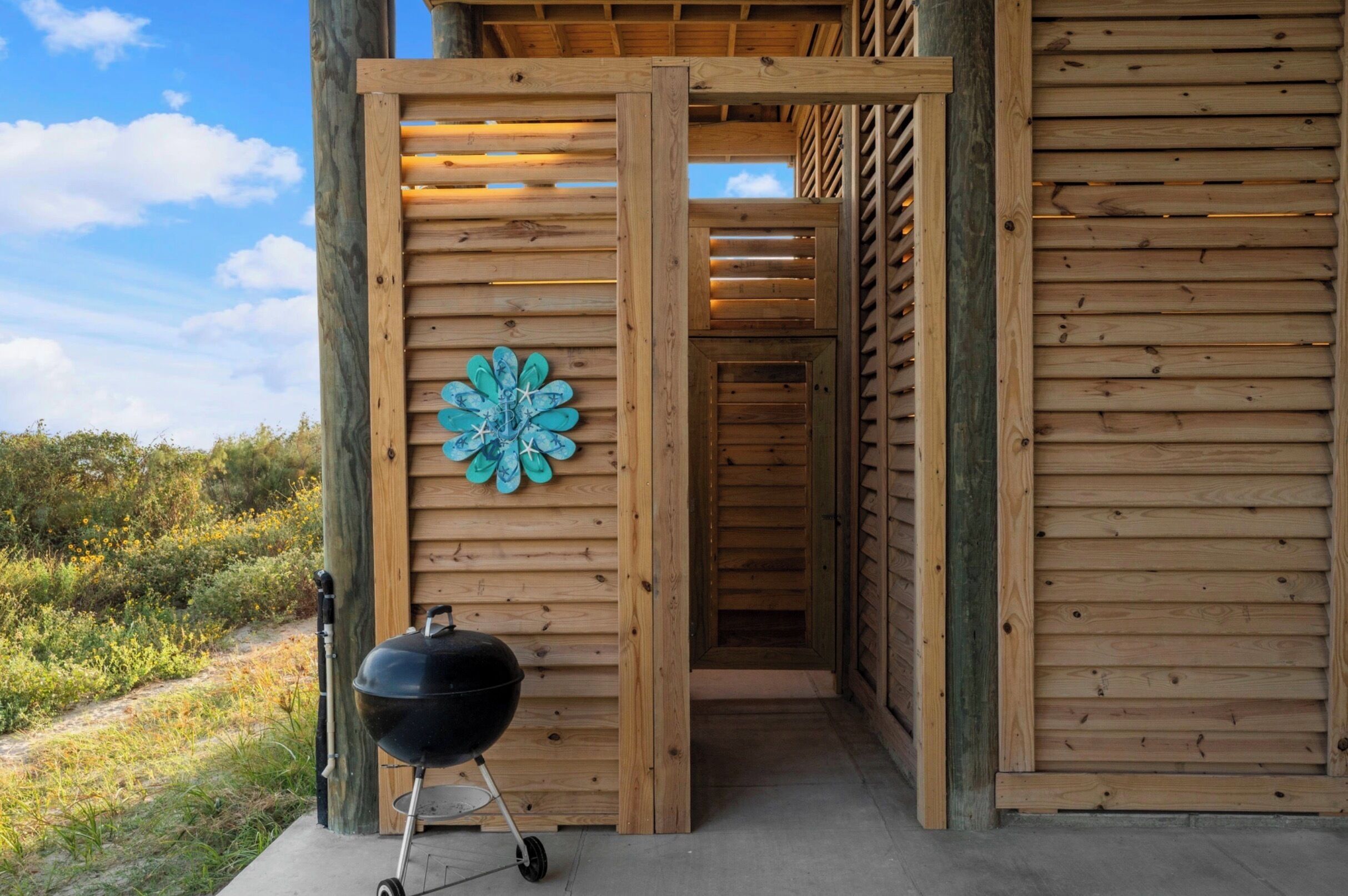 Une structure en bois agrémentée d’un gril et d’un élément décoratif mural.