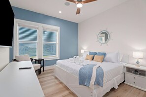 A bedroom with a bed, bedside tables, a desk, and a chair. - Sunrise Chateau I Beachfront Vacation Home (Bolivar Peninsula)
