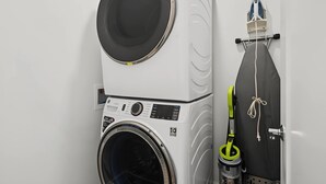 A compact laundry setup with a washing machine, dryer, and iron. - Modern Loop Retreat Duo - 2 Rooftops & 2 Garages (Atlantic City)
