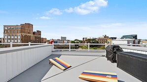 A rooftop terrace with a view of the city skyline, a barbecue grill, and two sun loungers. - Modern Loop Retreat Duo - 2 Rooftops & 2 Garages (Atlantic City)