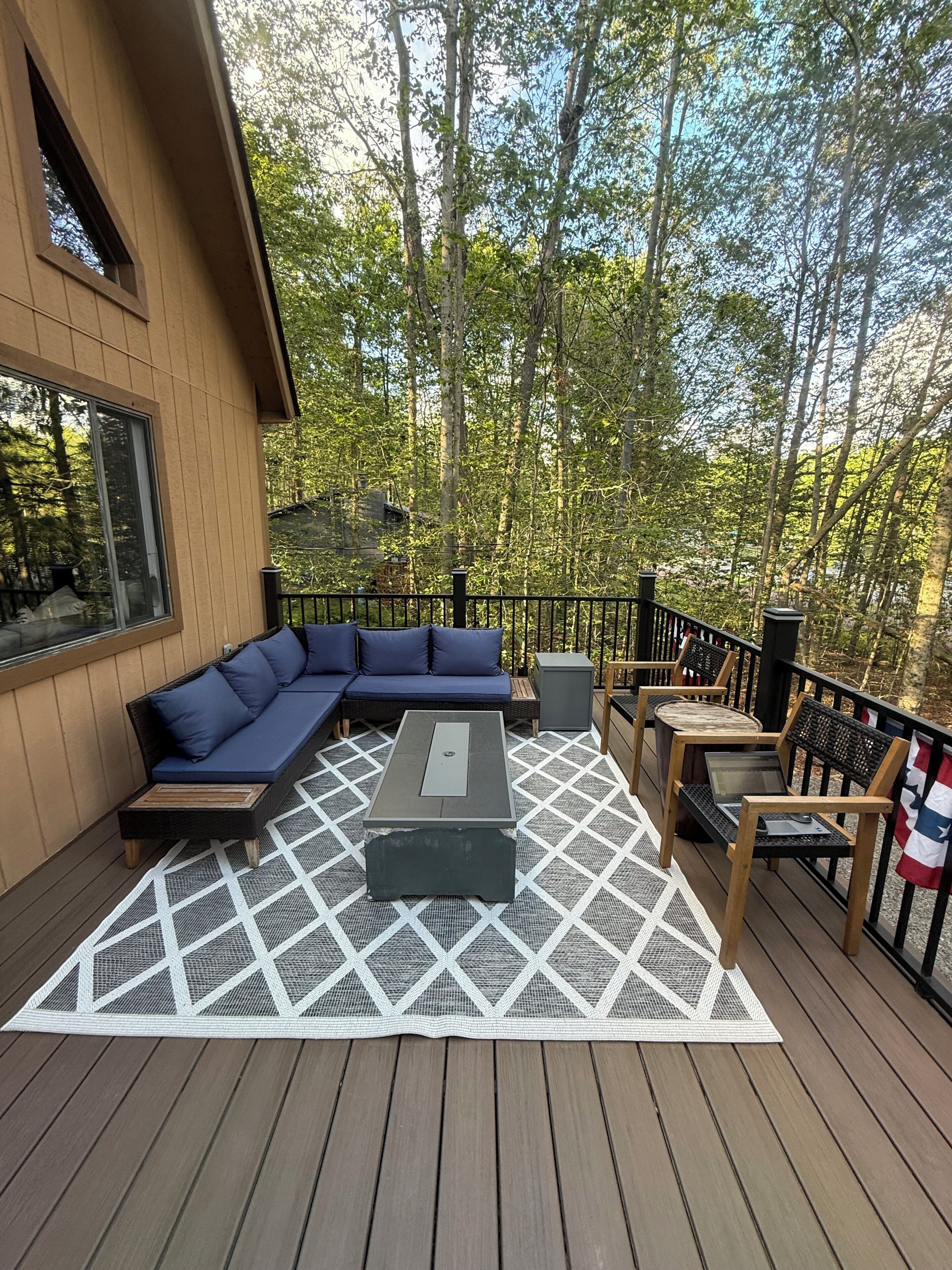 Eine Terrasse mit einer Couch, einem Couchtisch und Stühlen.