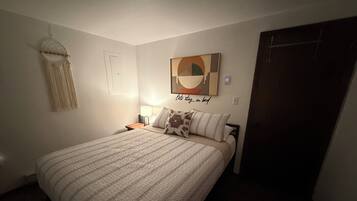 Tabla de planchar con plancha, internet y ropa de cama