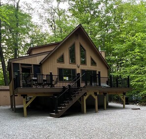 Eine Holzhütte mit Balkon, Treppe und einer Terrasse.