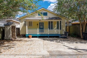 A single-story house with a front porch, a garage, and a fenced backyard.
