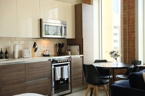 Eine moderne Küche mit Mikrowelle, Backofen und Essbereich mit Stühlen und Tisch.