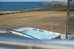 Un jacuzzi con vista al océano y campos.