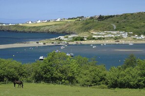 A coastal area with a beach, boats, and houses. - Swn y Don, Gwbert - Six Bedroom Cottage, Sleeps 12 (Cardigan)