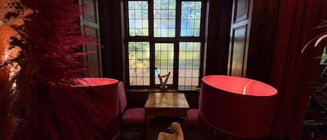 A room with a chess table, a statue, and a view through a window.