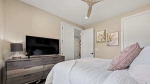 A bedroom with a bed, a TV on a dresser, and a ceiling fan. - Grand Kanab'n: Rooftop Hot Tub, Red Rock Views (Kanab)
