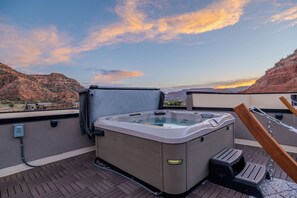 Ein Whirlpool auf einer Dachterrasse mit Blick auf eine Berglandschaft.