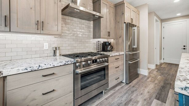 A modern kitchen with wooden cabinets, a stainless steel range, and a built-in oven. - Grand Kanab'n: Rooftop Hot Tub, Red Rock Views (Kanab)