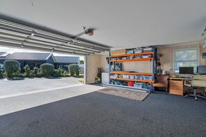 Un garage équipé d’un établi, d’étagères et d’un poste informatique.
