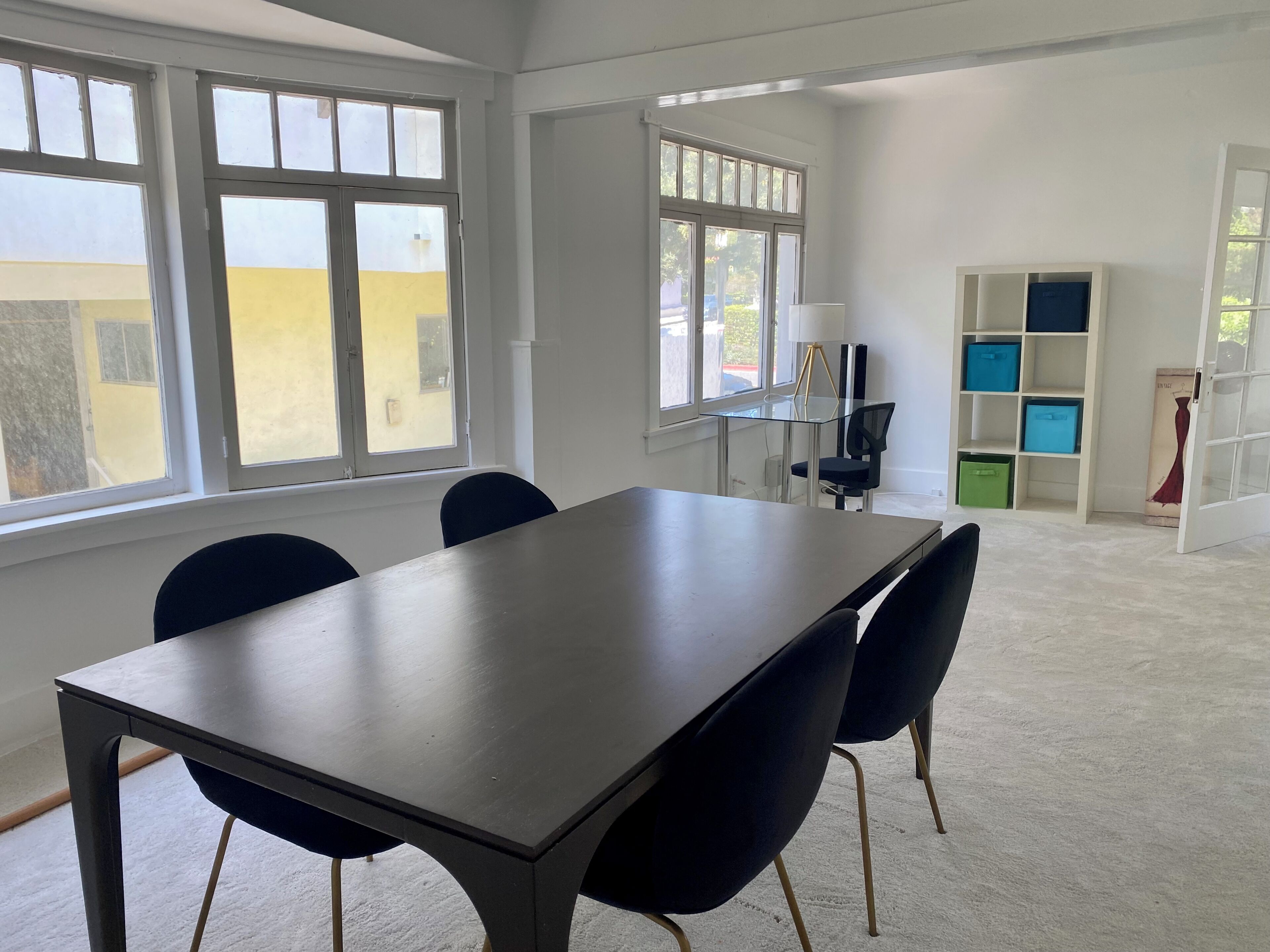 A room with a large table, chairs, and a bookshelf.