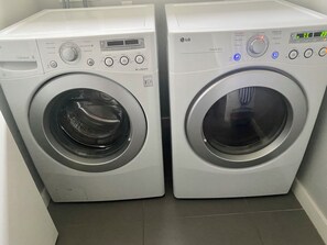 Deux lave-linge LG à chargement frontal, dotés d’un écran numérique, de panneaux de commande et d’une fonction de séchage par capteur.