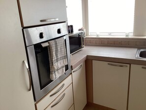 A kitchen with a built-in oven, a microwave, and a window above the sink. - 4 Star Holiday Home in Jerup (Jerup)