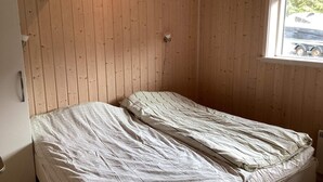 A small, single-bed room with wooden panel walls and a window. - 4 Star Holiday Home in Jerup (Jerup)