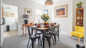 A dining area with a wooden table set for four, surrounded by black chairs. - Stunning 3Bed Victorian Central Home (Cambridge)