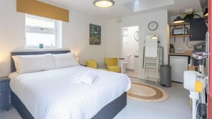 Ein Hotelzimmer mit Bett, einer kleinen Sitzecke, einer Küchenzeile und einem Badezimmer.