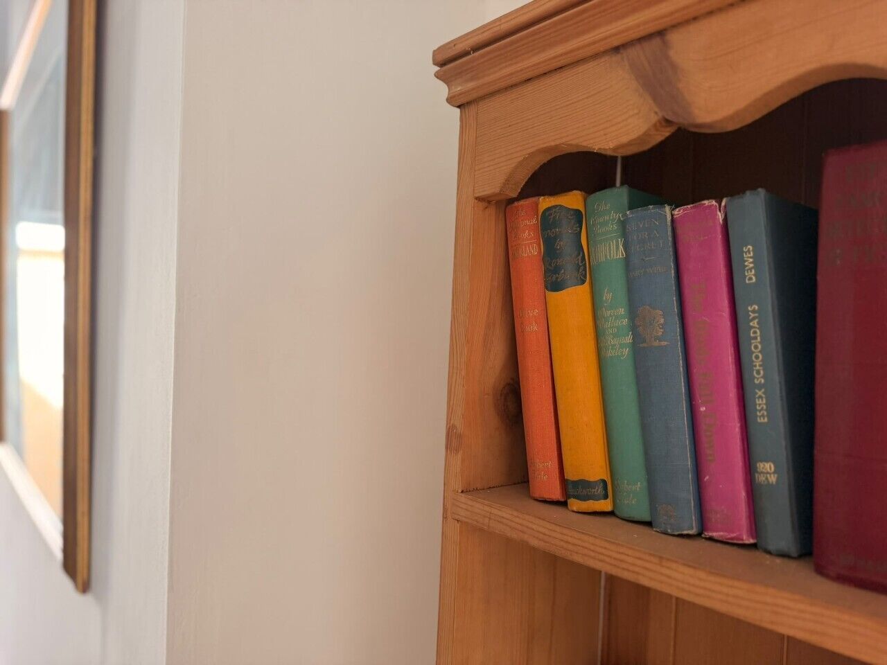 Una estantería de madera con varios libros.