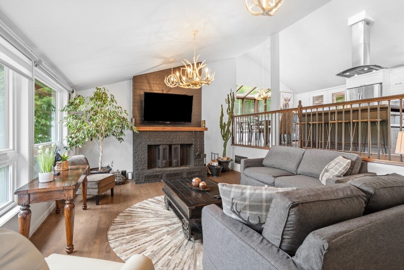 A modern living room with a fireplace, a sofa, a coffee table, and a television.