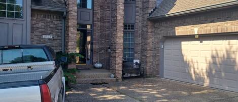 Une maison d’habitation avec un garage, une allée et un camion garé.